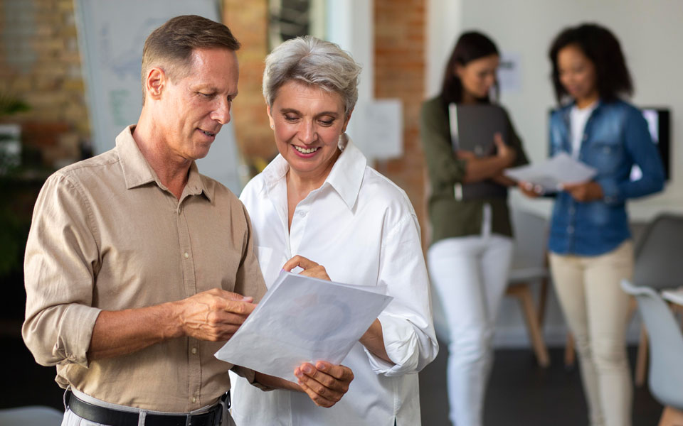 Seniors souriants avec un conseiller commercial