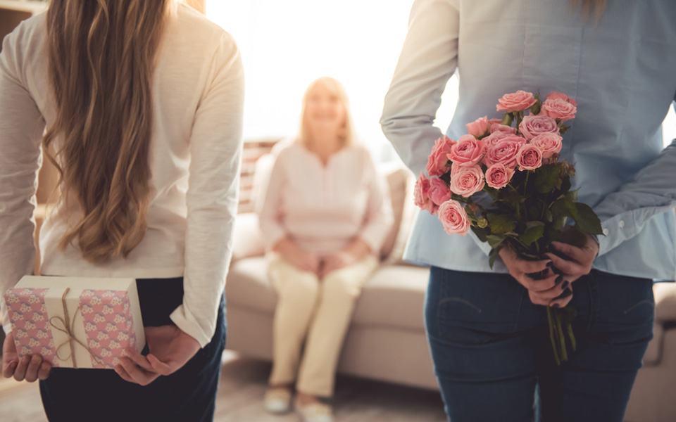 Adolescente et sa mere cache des fleurs pour fête  des mères 