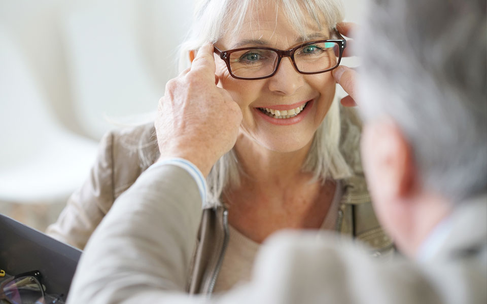 une personne âgée souriante portant des lunettes