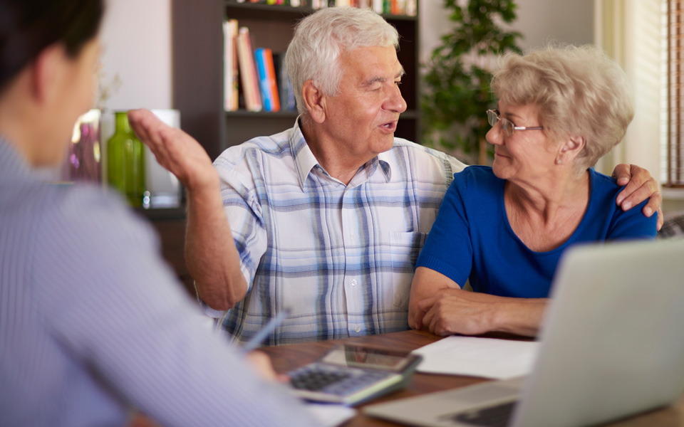 Deux seniors retraités devant un conseiller en assurance.