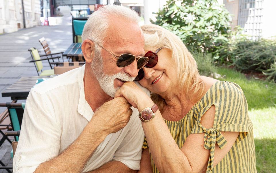 Un vieil homme heureux embrassant la main d'une dame