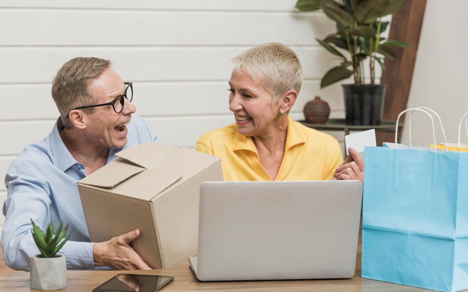 Homme et femme seniors ouvrant leurs sacs et cartons de courses