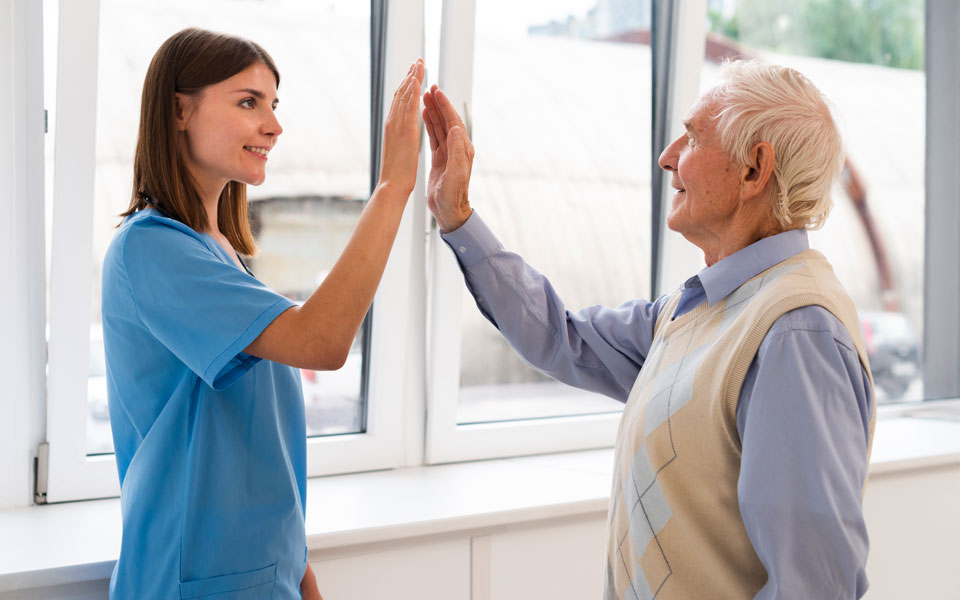 Une fillette souriante avec un senior résident à l'EHPAD