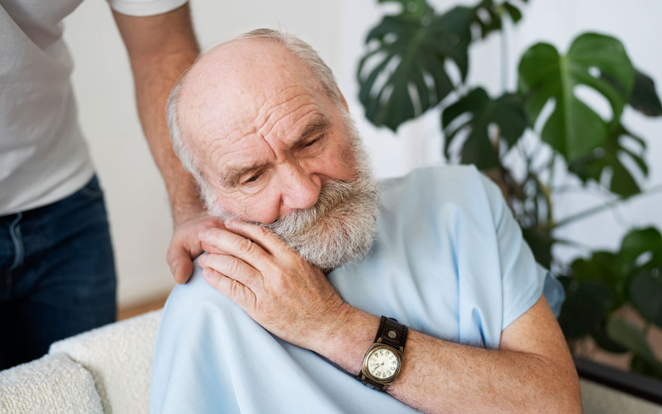 Personne âgée atteinte de la maladie de Parkinson assise et accompagnée
